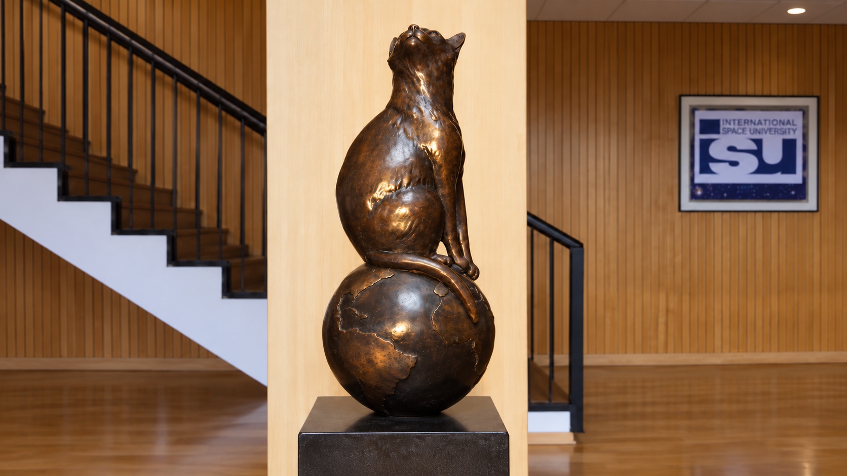 Bronzestatue von Félicette auf einer Weltkugel in der International Space University in Straßburg, mit nach oben gerichtetem Blick.